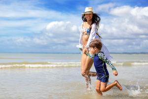 a woman and a child playing on the beach at Hotel Brisa da Praia in Porto Seguro