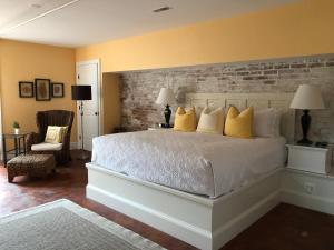 ein Schlafzimmer mit einem großen weißen Bett mit gelben Kissen in der Unterkunft Suites at 249 in Culpeper