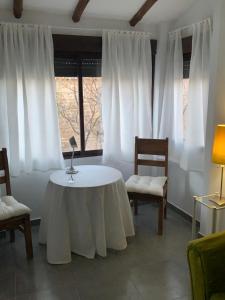 une chambre avec une table, deux chaises et une fenêtre dans l'établissement Vivienda con fines turísticos La Barbacana del Salvador, à Úbeda