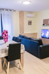 un soggiorno con divano blu e tavolo di Like at home ad Alghero