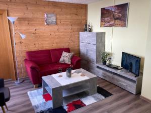 a living room with a red couch and a table at Alpenhaus Denver in Uttendorf