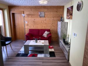 a living room with a red couch and a table at Alpenhaus Denver in Uttendorf