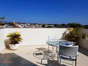 カショエイラ・パウリスタにあるVideiras Palace Hotelのバルコニーにテーブルと椅子が置かれたパティオ