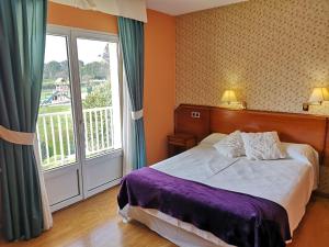 - une chambre avec un lit et une grande fenêtre dans l'établissement Hotel y Casona El Carmen, à Perlora