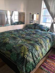 1 dormitorio con 1 cama con edredón verde en LEONE PARIS, en Windhoek