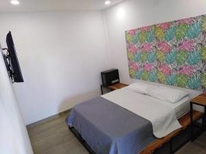 マリニリャにあるHotel La Aldea del Orienteのベッドルーム1室(壁に絵画が描かれたベッド1台付)