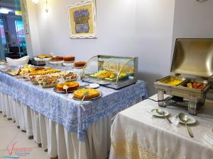 una línea de buffet con comida y postres en las mesas en Videiras Palace Hotel, en Cachoeira Paulista