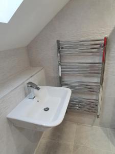 a bathroom with a white sink and a metal door at Beech Cottage in Rothbury