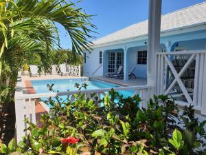 a villa with a swimming pool and a house at Luxury secluded villa with private pool sleeps six in Jolly Harbour