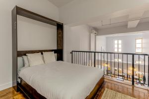 a bedroom with a large bed and a balcony at Les Immeubles Charlevoix - Le 1179 in Quebec City