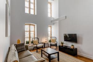 a living room with a couch and a tv at Les Immeubles Charlevoix - Le 1179 in Quebec City