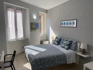 a bedroom with a bed and a chair and windows at SeaBreeze Vernazza in Vernazza