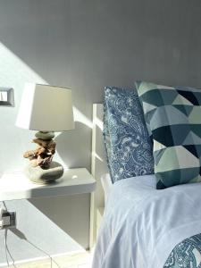 a bedroom with a bed with a lamp and pillows at SeaBreeze Vernazza in Vernazza