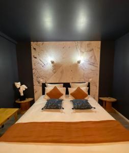um quarto com uma cama grande e 2 almofadas em CHARMES EN VILLE Le Charme Poétique em Montluçon