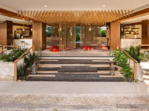 a lobby of a hotel with stairs and tables at Naala Tulum in Tulum