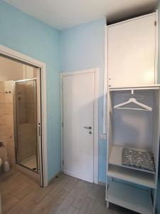 a bathroom with blue walls and a closet and a door at SeaBreeze Vernazza in Vernazza