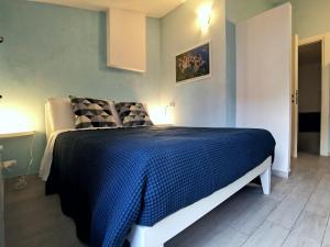 a bedroom with a bed with a blue comforter at SeaBreeze Vernazza in Vernazza