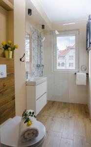 uma casa de banho com um WC, um lavatório e uma janela em Song`s Apartment em Sopot