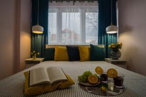 uma cama com um livro aberto e um prato de fruta em Song`s Apartment em Sopot
