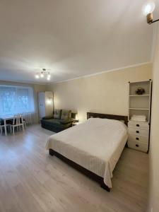 1 dormitorio con cama, sofá y mesa en Historical Centre Apartments, en Leópolis