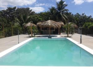 a swimming pool with umbrellas and a resort at Badaboom Hostal & Surf in Aposentillo