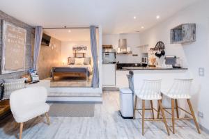 a kitchen and living room with a bed and a counter at Un Cottage Alpin chaleureux dans le coeur d Annecy avec 2 vélos in Annecy