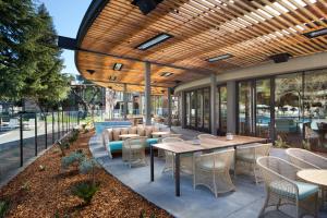 圣罗莎Flamingo Resort & Spa Santa Rosa Sonoma, Tapestry by Hilton的木制天花板下设有带桌椅的天井。
