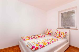 ein weißes Sofa mit bunten Kissen in einem Zimmer in der Unterkunft Apartment in Klimno - Insel Krk 38204 in Klimno