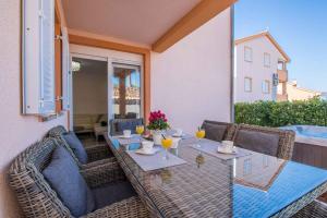 eine Terrasse mit einem Tisch und Stühlen mit Getränken darauf in der Unterkunft Apartment in Klimno - Insel Krk 38204 in Klimno