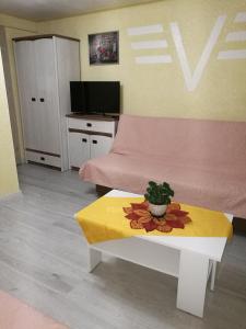 a living room with a pink bed and a table at POKOJE GOŚCINNE BRYZA in Mielno