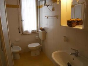 a bathroom with a toilet and a sink and a mirror at Two-Bedroom Apartment in Bibione VIII in Bibione