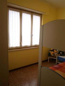 a bedroom with two windows and a bed and a bed frame at Two-Bedroom Apartment in Bibione VIII in Bibione