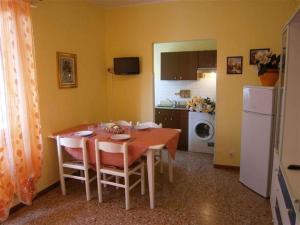 a dining room with a table and a kitchen at Two-Bedroom Apartment in Bibione VIII in Bibione