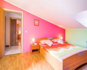 a bedroom with a bed and a pink wall at Apartment in Vrbnik/Insel Krk 14527 in Vrbnik