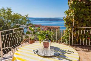 a table with a vase on it on a balcony at Apartment in Crikvenica 14049 in Klanfari