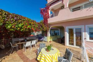 a patio with a table and chairs in front of a house at Apartment in Crikvenica 14049 in Klanfari