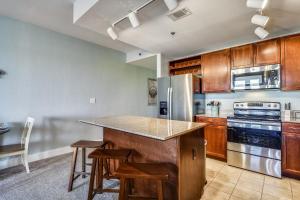 una cucina con armadi in legno e un'isola cucina con sgabelli. di Laketown Wharf Resort #226 by Book That Condo a Panama City Beach