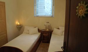 two twin beds in a room with a window at Apartment Dyonis Perast in Perast