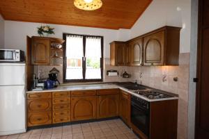 a kitchen with wooden cabinets and a white refrigerator at Apartment in Silo/Insel Krk 14540 in Šilo