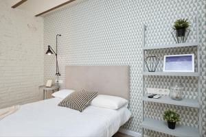 カンブリルスにあるVestal Suites Classicの白レンガの壁、ベッド付きのベッドルーム1室 +13枚の写真