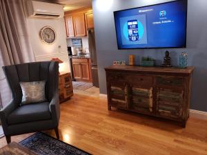 a living room with a chair and a flat screen tv at Maui Tranquility II in Kihei