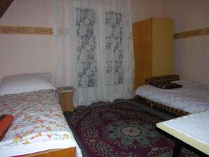 a bedroom with two beds and a table and a window at Holiday home Balatonlelle - Balaton 19071 in Balatonlelle