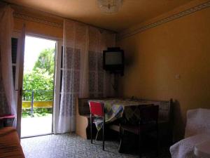 a room with a table and a television on the wall at Holiday home Balatonlelle - Balaton 19071 in Balatonlelle +4 photos
