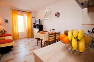 a kitchen with a bowl of fruit on a table at Apartment Vrbnik 8 in Vrbnik +7 photos