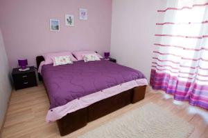 a bedroom with a purple bed with two pillows at Apartment Vrbnik 8 in Vrbnik