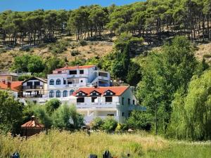 a large white house with a red roof on a hill at Apartment in Lopar with sea view, balcony, air conditioning, Wi-Fi (4607-4) in Lopar