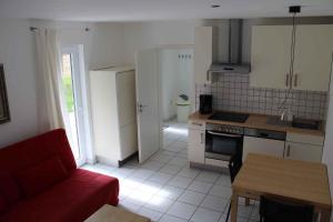 a living room with a red couch and a kitchen at Apartment Rambin 2 in Gurvitz