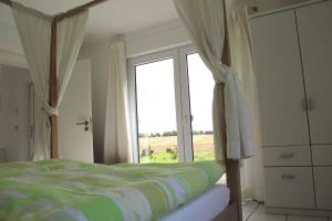ein Schlafzimmer mit einem Bett und einem großen Fenster in der Unterkunft Apartment Rambin 2 in Gurvitz