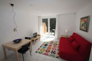 ein Wohnzimmer mit einem roten Sofa und einem Tisch in der Unterkunft Apartment Rambin 2 in Gurvitz