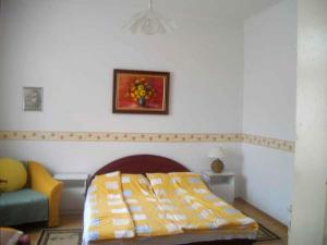 バラトンケレストゥールにあるHoliday home in Balatonmariafürdo 19232のベッドルーム1室(ベッド1台付)が備わります。壁に絵が飾られています。